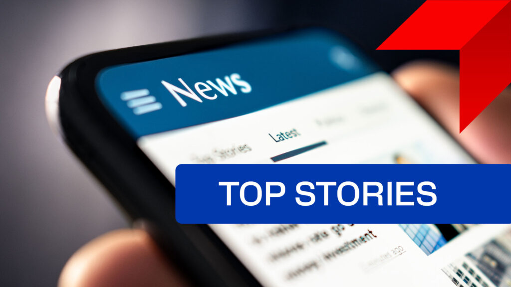 Person holding mobile device with news feed